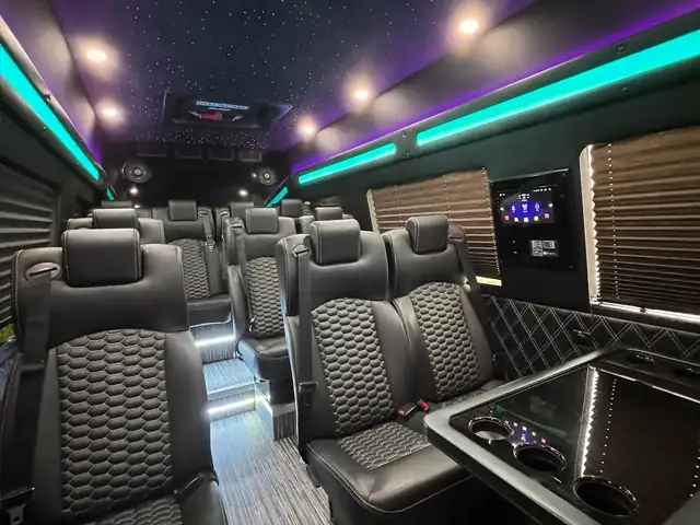 Executive Sprinter cabin with starlit headliner, teal accent lighting and rows of leather seats — NYC Sprinter services