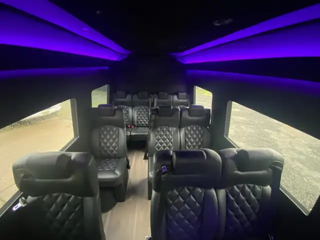 Executive Sprinter cabin interior with violet ceiling lighting and rows of quilted leather seats — Private Transfer NYC