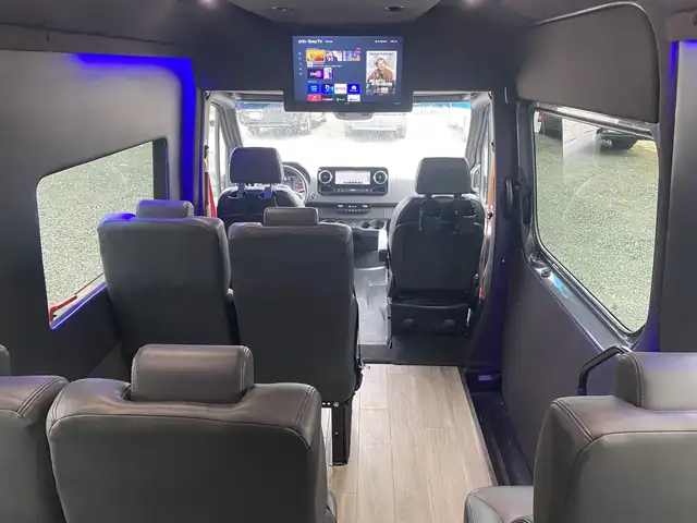 Executive Sprinter view toward the driver with leather seats, a ceiling monitor and a windshield view — NYC Sprinter guides