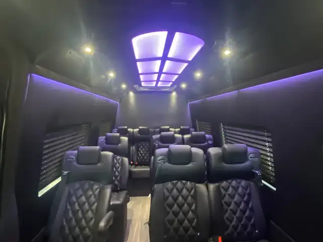 Executive Sprinter cabin from the rear with a glowing purple ceiling panel and rows of leather seats — Sprinter Service Newark — Mercedes-Benz