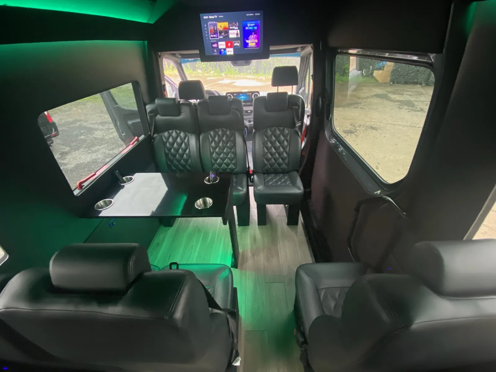 Executive Sprinter with green accent lighting, a ceiling TV and black leather seats by the windows — 10 Best Corporate Car & Sprinter Services NYC (2026)