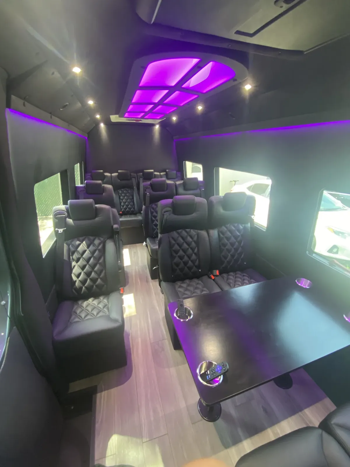 Executive Sprinter with a purple ceiling panel, leather seats and a dark folding table — Shuttle Service Long Island — Mercedes Sprinter