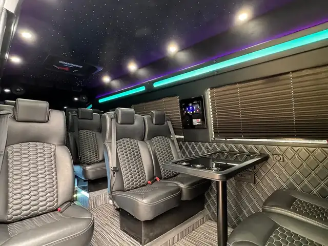 Executive Sprinter with gray leather seats, a table, teal LED and a wall TV — Sprinter service in Upper East Side