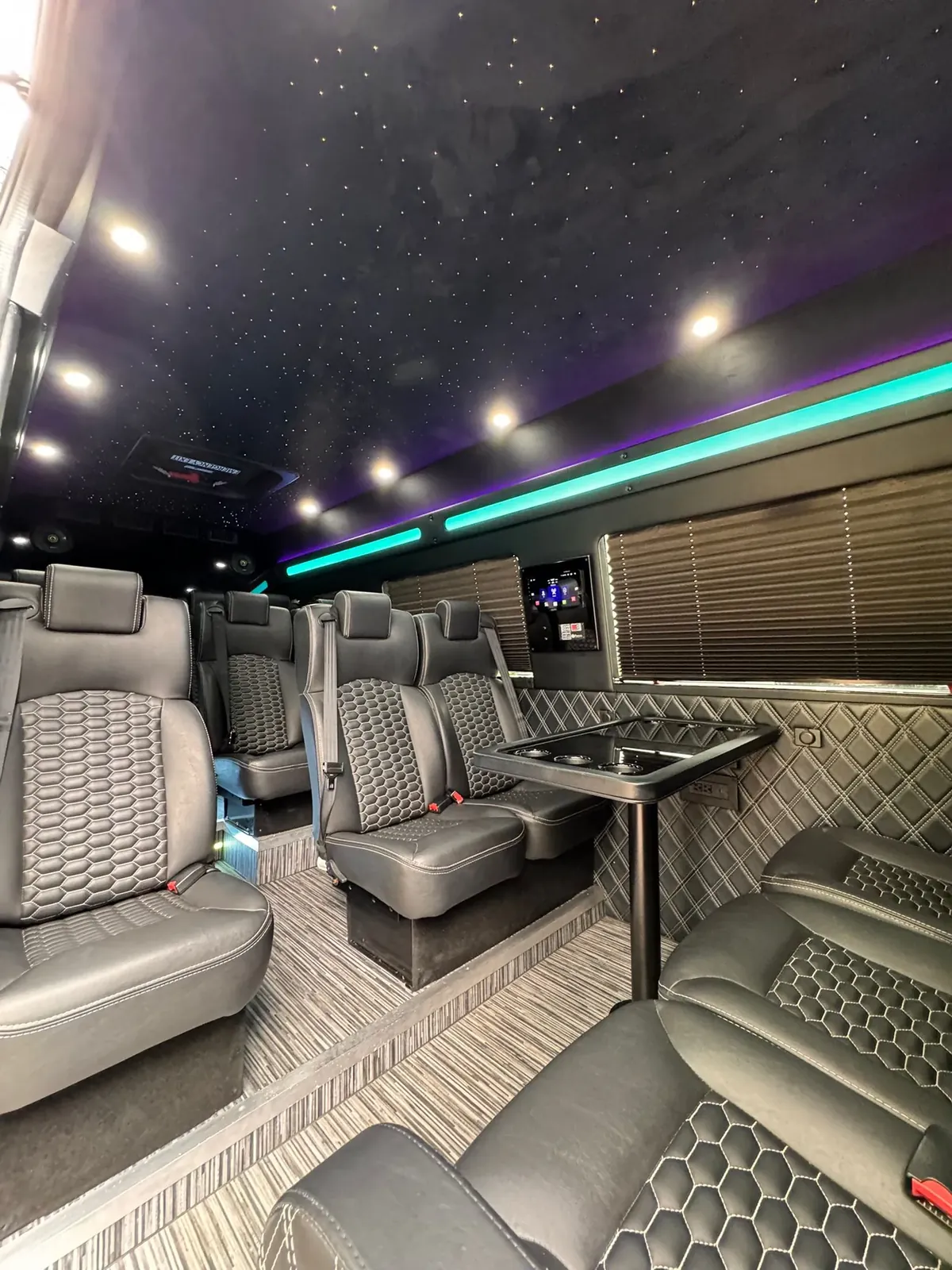 Executive Sprinter with gray leather seats, a table, teal LED and a wall TV — Sprinter service in SoHo