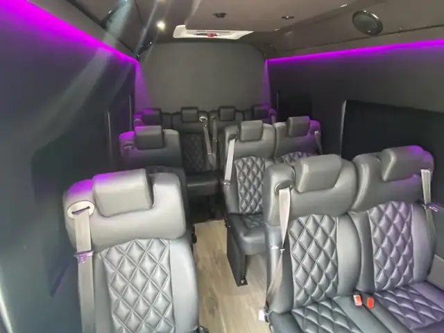 Executive Sprinter with magenta accent lighting and gray leather seats along a light wood floor — Private Transfer NYC