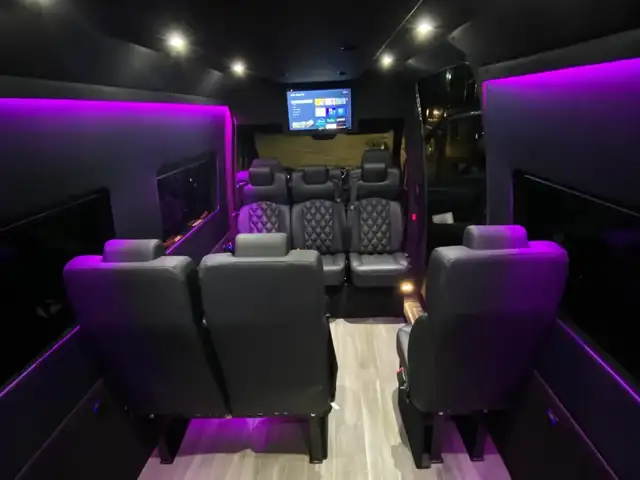 Executive Sprinter with magenta side lighting, leather seats and a small TV at the front — Manhattan to Boston, MA transfers