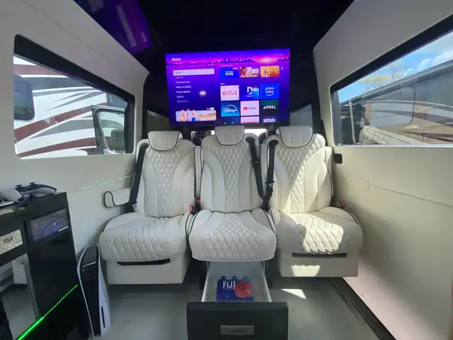 Jet Sprinter with a row of three white leather seats facing a big wall-mounted TV — Jet Sprinter NYC