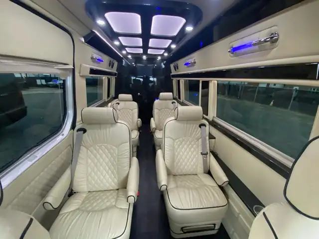 Jet Sprinter aisle of cream leather reclining chairs under a lit ceiling panel — Jet Sprinter NYC