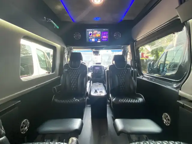 Jet Sprinter with black leather captain chairs, blue ceiling light and a TV toward the windshield — Sprinter service in Upper East Side