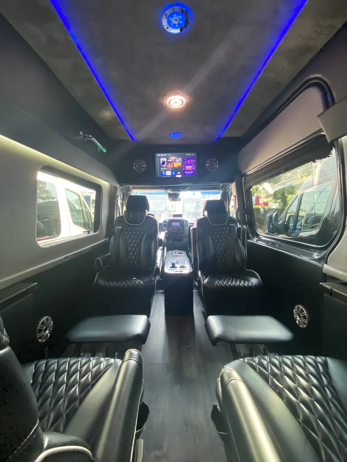 Jet Sprinter with black leather captain chairs, blue ceiling light and a TV toward the windshield — 10 Best Airport Sprinter Van Services in NYC (2026)