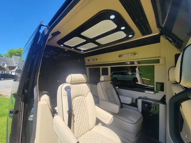 Jet Sprinter open side door showing cream diamond-stitched captain chairs and a panel ceiling — EWR to Midtown Manhattan transfers