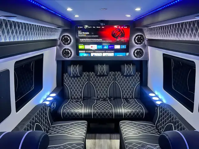Jet Sprinter with a black and white leather rear sofa, a large TV and quilted white wall panels — Shuttle Service New Jersey — Mercedes Sprinter