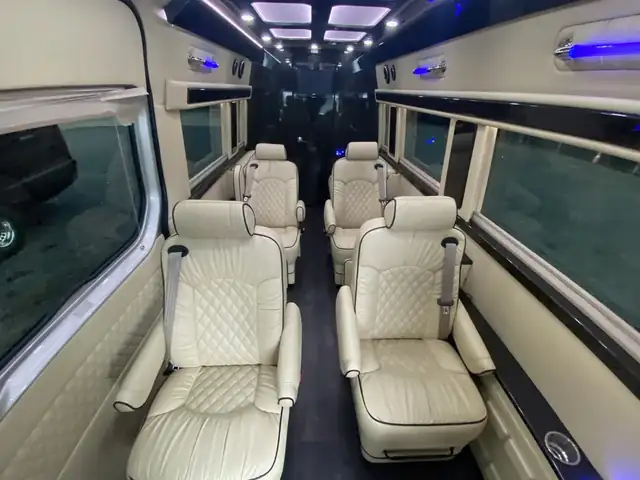 Jet Sprinter with cream diamond leather chairs in facing pairs and a lit panel ceiling — EWR to Midtown Manhattan transfers