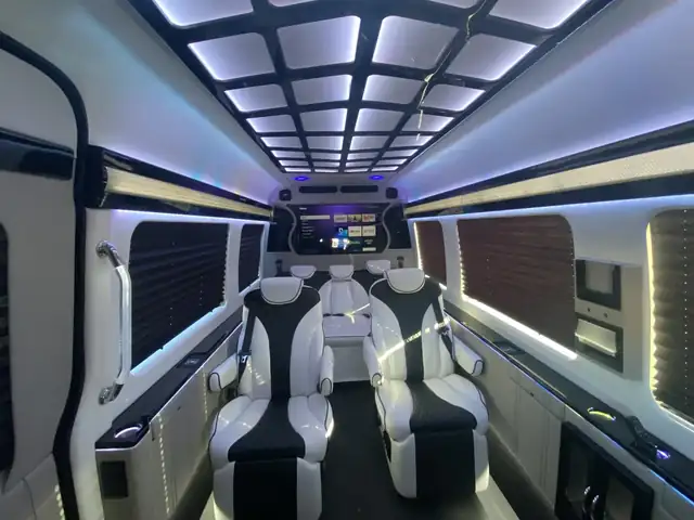 Jet Sprinter with black and white leather chairs, a lit coffered ceiling and cream side panels — Corporate Shuttle