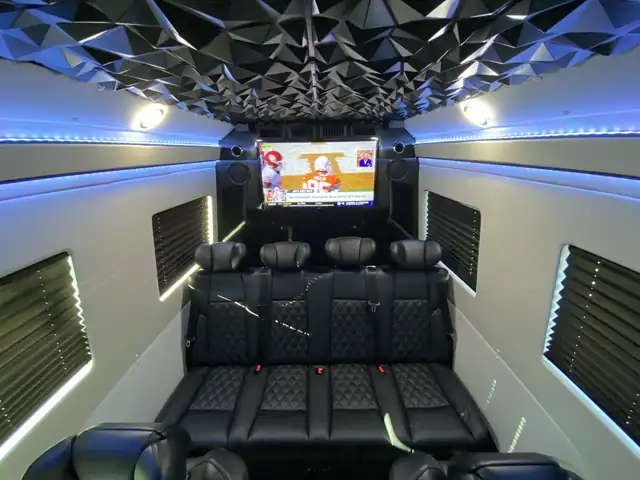 Jet Sprinter with a black leather rear bench, a wall TV and a faceted black ceiling — Manhattan to Boston, MA transfers