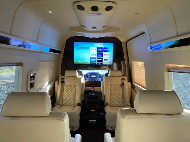 Jet Sprinter looking forward past cream leather seats to a large TV and cream headliner — Sprinter service in Williamsburg