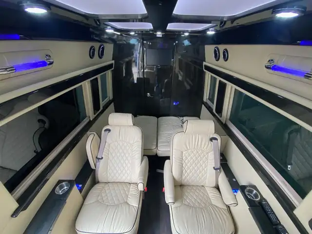 Jet Sprinter with cream diamond-stitched leather chairs in a pair beneath a paneled ceiling — Sprinter rates
