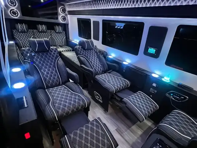 Jet Sprinter seen from the rear, with black leather chairs edged in white and blue ceiling lights — Van for Hire NYC: 12–15 Passenger Mercedes Sprinter