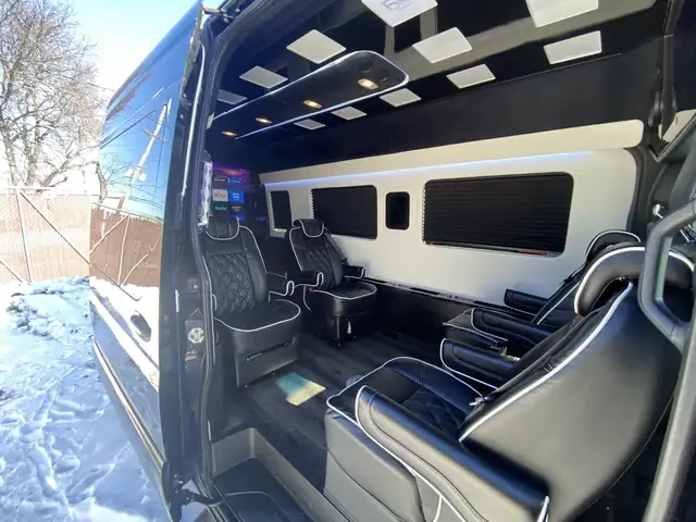 Jet Sprinter open door showing black leather captain chairs, a panel ceiling and a snowy backdrop — Corporate Transportation New Jersey — Mercedes Sprinter