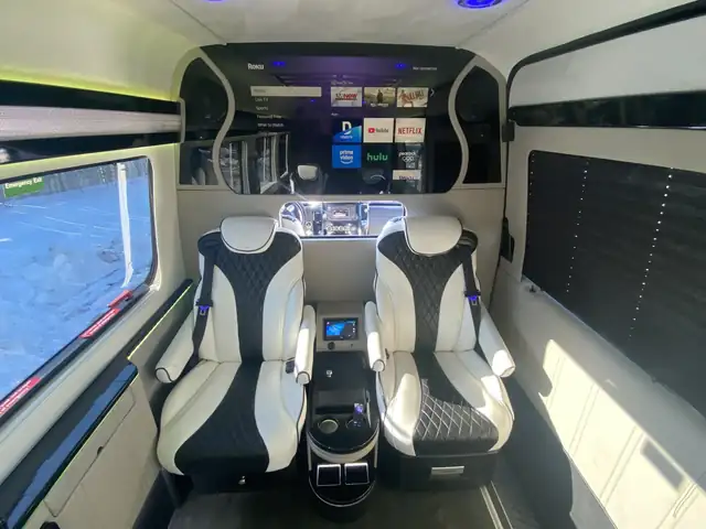 Jet Sprinter with two black and white leather captain chairs around a console and a large screen — Minibus rental NYC