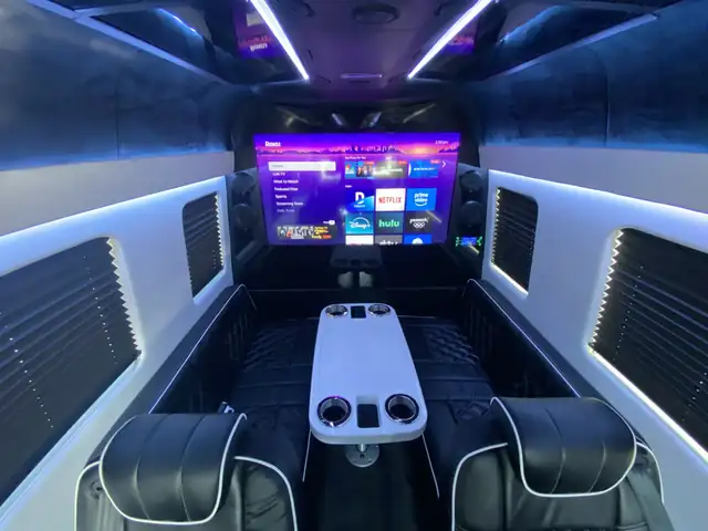 Jet Sprinter looking toward a large front TV with a white center table and black leather seats — JFK to Midtown Manhattan transfers