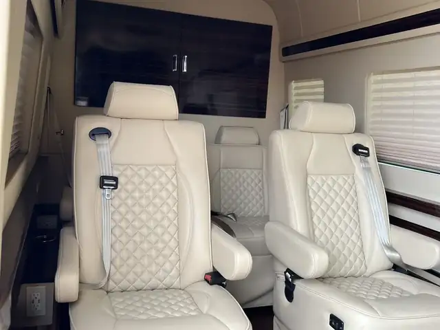 Jet Sprinter with two cream leather recliners, window shades and a dark cabinet wall — NYC Sprinter blog