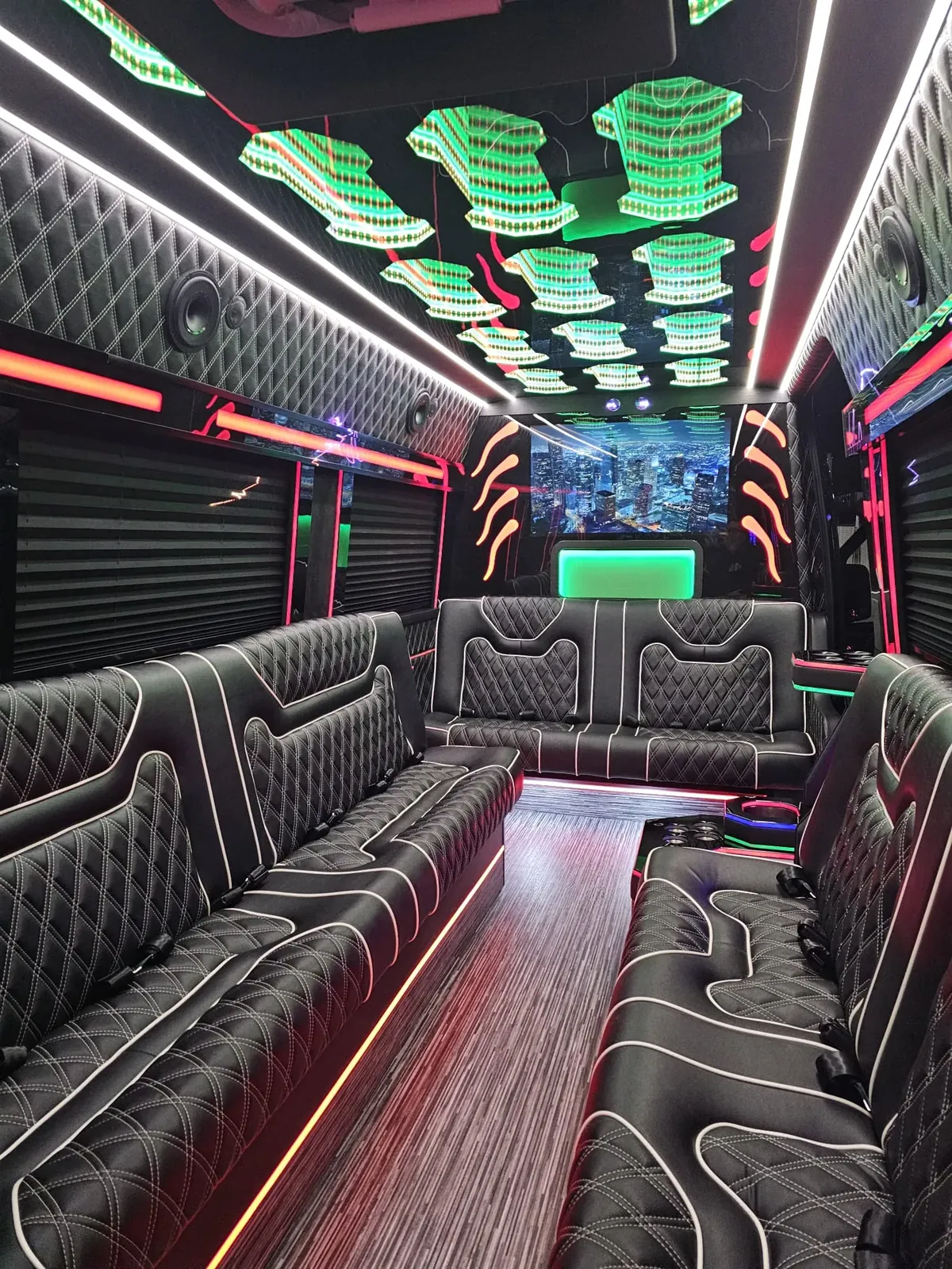 Limo Sprinter with a rainbow-lit ceiling, black sofas trimmed in white and a front TV — Wedding Transportation