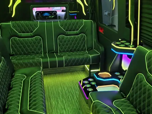 Limo Sprinter with green floor and ceiling lighting and a long black sofa layout — Wedding Transportation