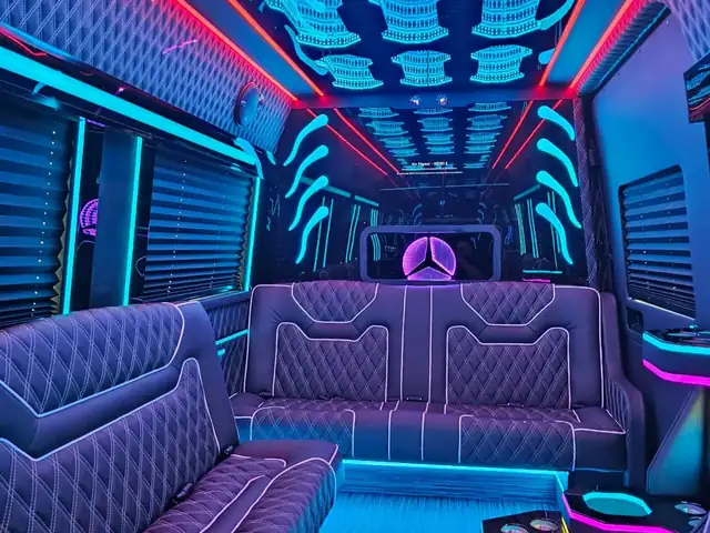 Limo Sprinter with a cyan sculpted ceiling, red edge lighting and a lit Mercedes star behind blue sofas — Wedding Shuttle Service Long Island — Mercedes Sprinter